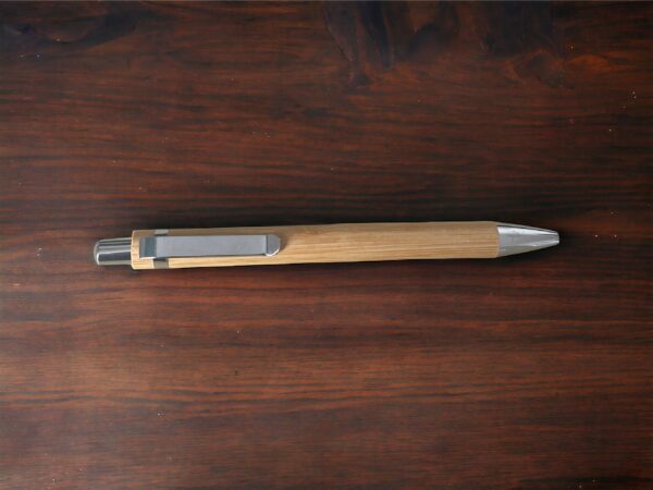 Bamboo pen on a dark wooden surface