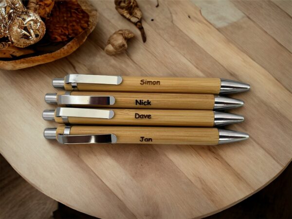 4 bamboo pens engraved with names on them