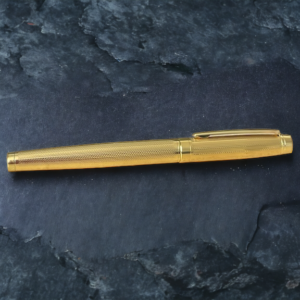 golden pen on slate background