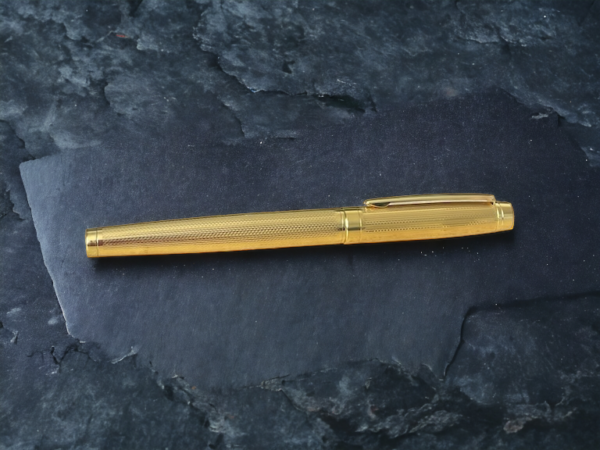 golden pen on slate background