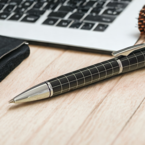 Chequered black pen on a desk with a laptop