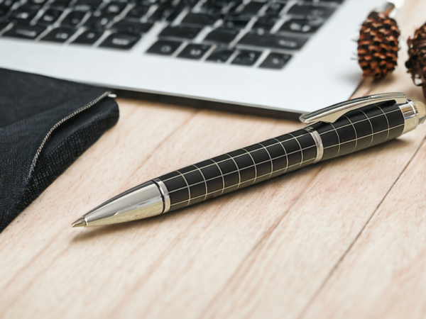 Chequered black pen on a desk with a laptop