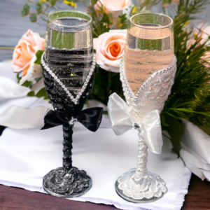 Champagne glasses with pink champagne in bride and groom attire