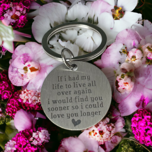 a round keyring laying on a bed of pink flowers