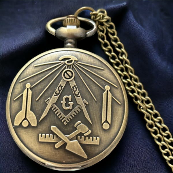 A masonic pocket watch showing the masonic symbols lying on a black cloth