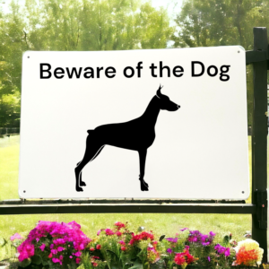 White sign with Beware the dog written on it and a picture of a dog