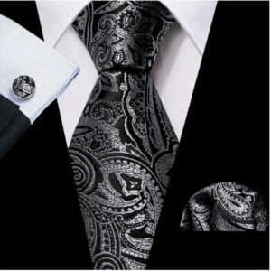 A black suit with a black and silver paisley tie, cufflinks and pocket sqare